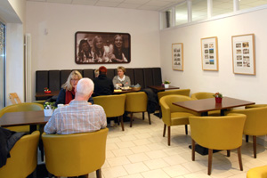 Menschen sitzen auf Stühlen in einem Cafe