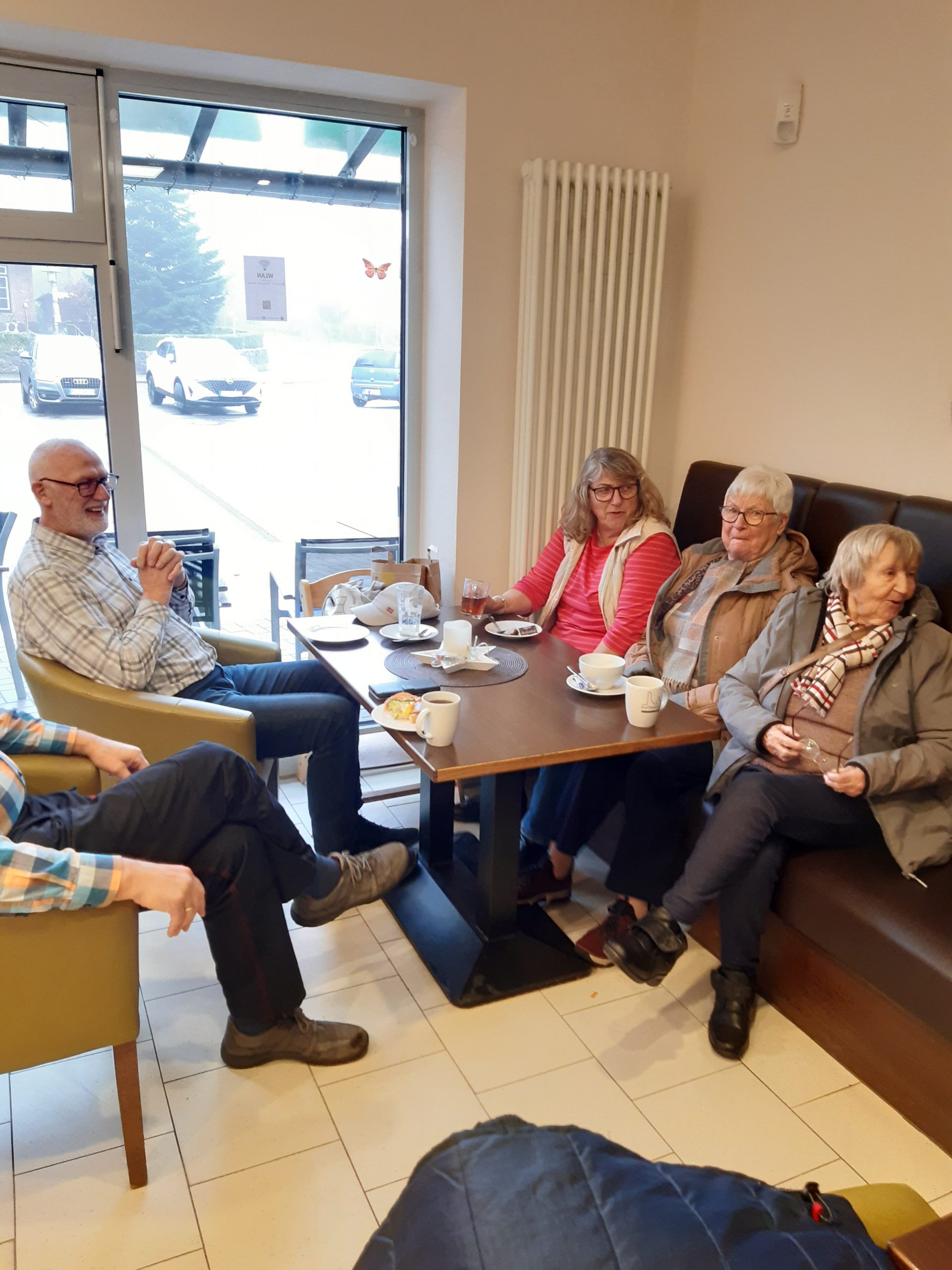 Menschen sitzen auf Stühlen in einem Cafe
